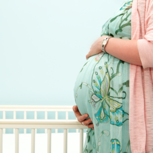 A pregnant woman is stand on terrace and feel fresh air.