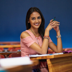 Girl studying at table with books and notes.
