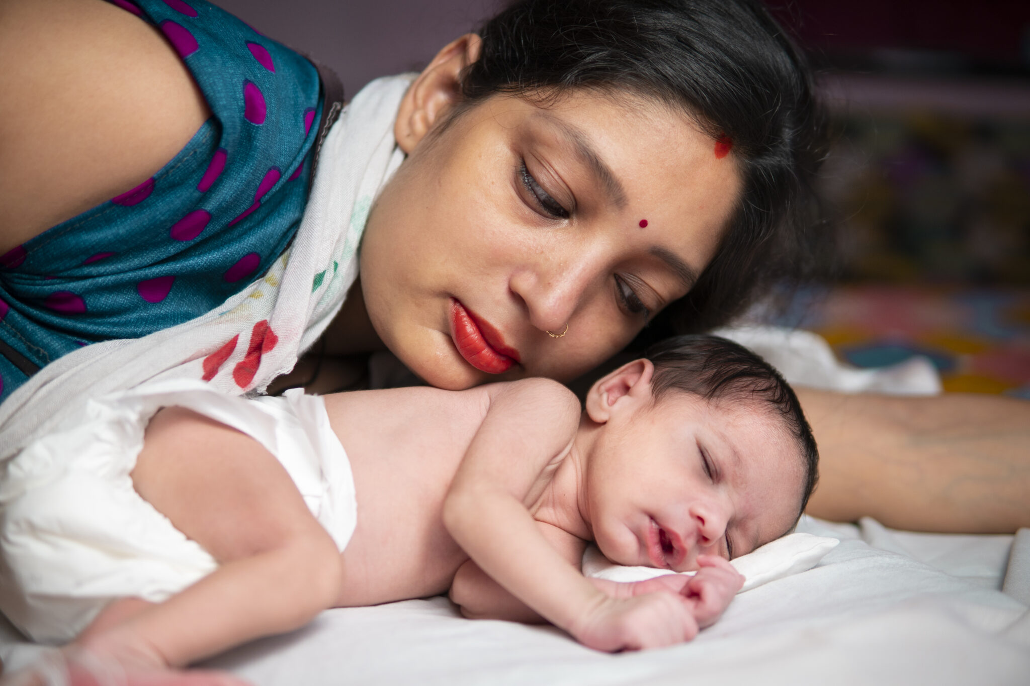 Close-up of cute baby boy lying on bed at home.